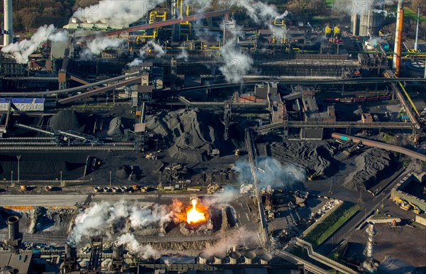 Glowing hot slag from iron production is tipped from a ladle car into a pit