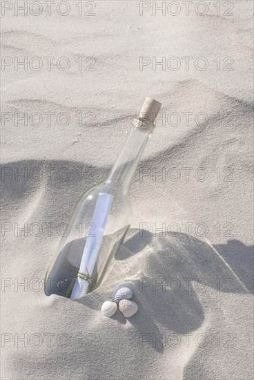 Bottle with a message inside on a sandy beach