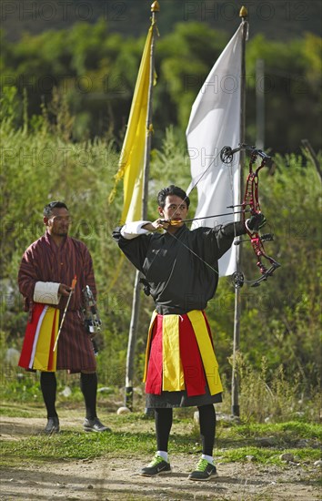 Archers with a high-tech bow wearing Gho dresses
