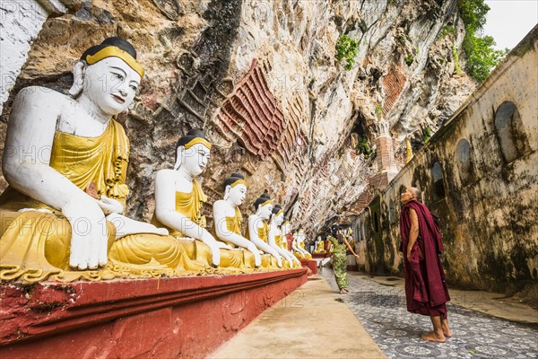 Monk looking at the seated Buddha statues