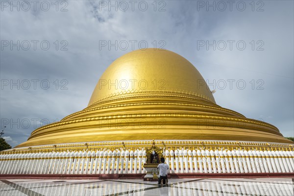 Praying man in front of Kaunghmudaw pagoda or Yaza Mani Sula Kaunghmudaw or Rajamanicula