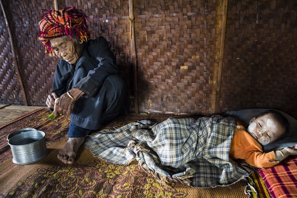 Old woman and sleeping child with thanaka paste in the face of hill tribe Pa-O or Pa-Oh or Pao or Black Karen or Taungthu or dew-soo
