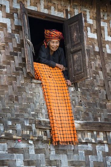 Old woman looking out of a lodge window