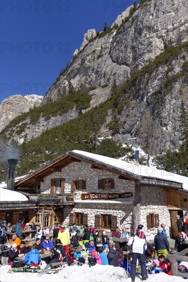 Rifugio Scotoni hut in winter with skiers