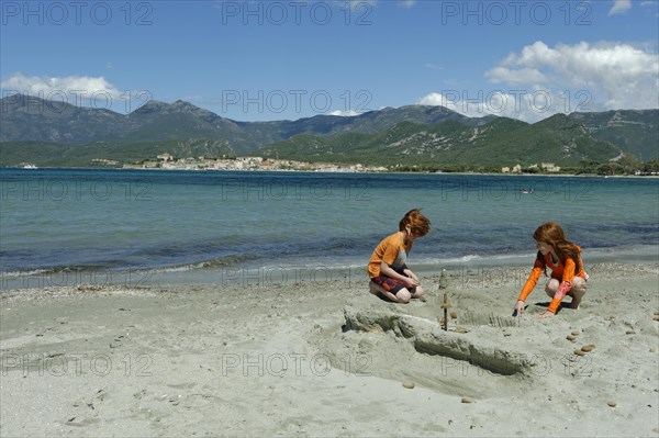 Children playing on the beach and bay of Saint Florent