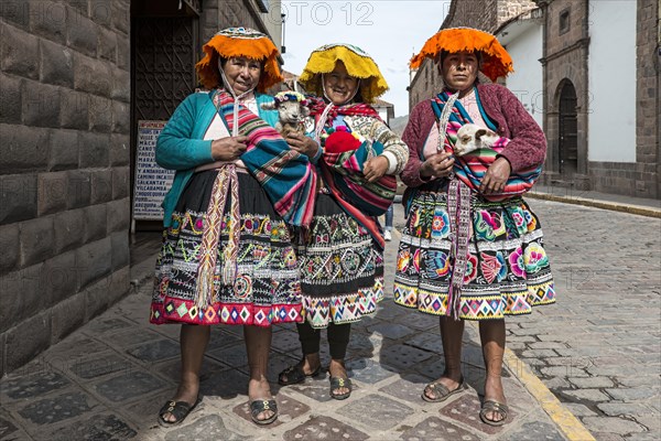 Traditionally dressed women with lambs