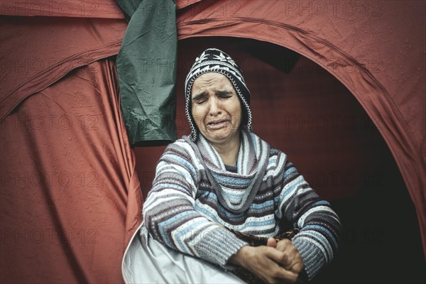 Desperate woman from Afghanistan weeping in her tent