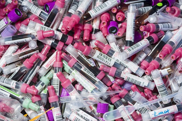 Transparent monovettes containing different blood samples in a garbage bin