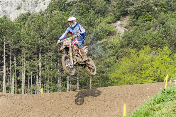 Motorcyclist on a motocross bike jumping through the air