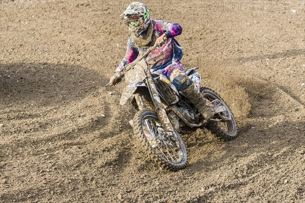 Motorcyclist on a motocross bike riding on a dirt track