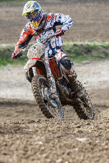 Motorcyclist on a motocross bike riding on a dirt track