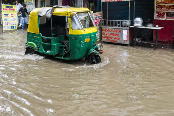 A motor rickshaw is moving through the flooded streets of the suburb Paharganj after a heavy monsoon rainfall