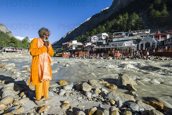 A devotee is praying at the waterfront of the young river Ganges