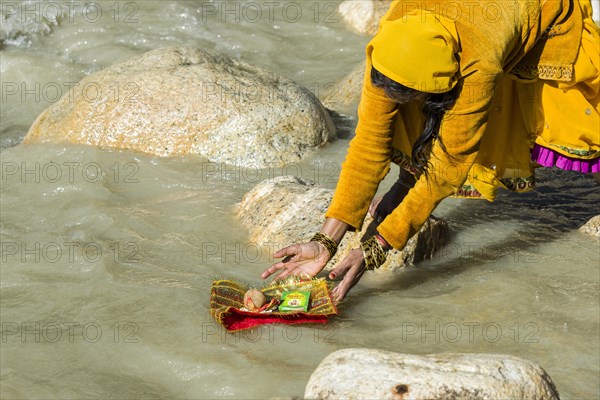 A female pilgrim at the banks of the river Ganges is praying