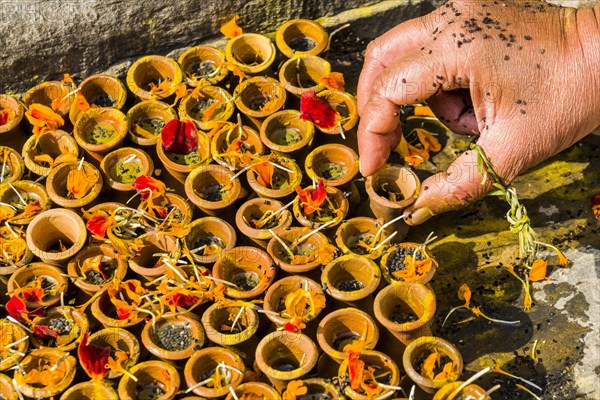 Hand of a devoty is taking small clay pots during the religeous ceremony Srad at Pashupatinath Temple