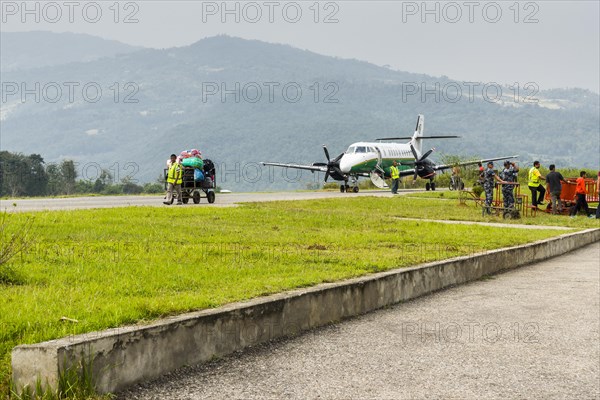 A worker is transporting luggage to the airport of Tumlingtar