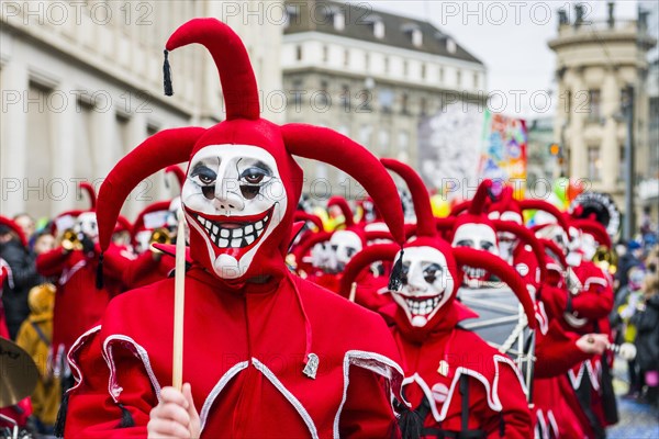 Members of the Gugge marching brass bands wearing fancy dresses and masks at the great procession at the Carnival of Basel