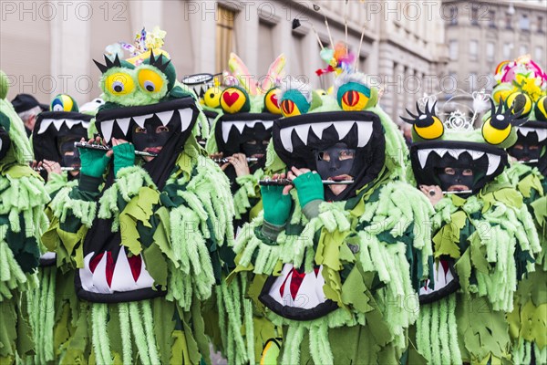 Members of the Gugge marching brass bands wearing fancy dresses and masks at the great procession at the Carnival of Basel