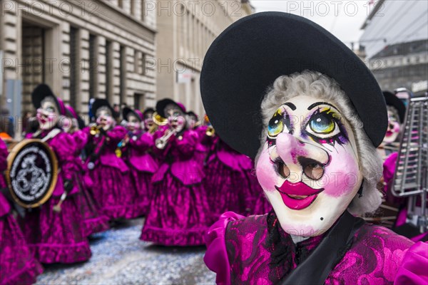 Members of the Gugge marching brass bands wearing fancy dresses and masks at the great procession at the Carnival of Basel