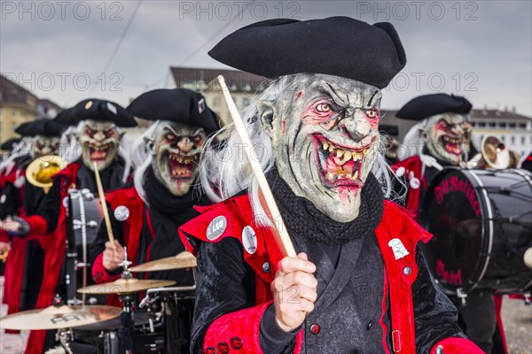 Members of the Gugge marching brass bands wearing fancy dresses and masks at the great procession at the Carnival of Basel