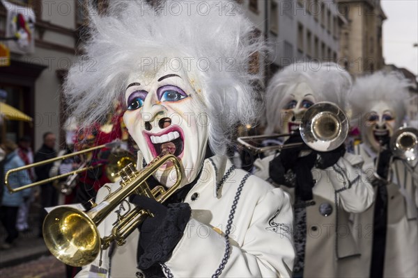 Many different groups of masked people walking through the streets of Basel