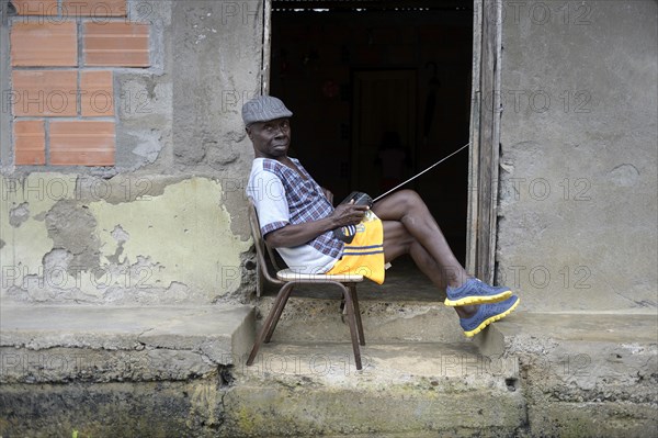 Man sitting with radio at the door