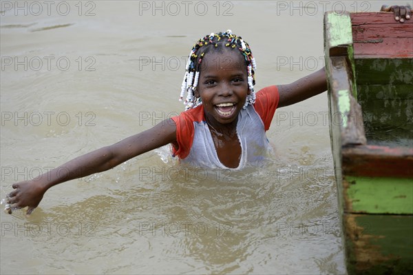 Girl playing beside boat in river