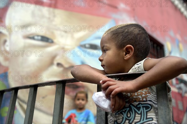 Boy in front of the graffiti of a baby's cace