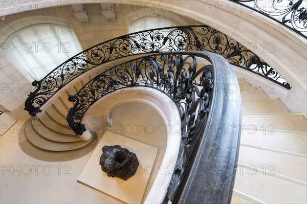 Circular staircase with the statue Ugolino and His Son by Jean-Baptiste Carpeaux