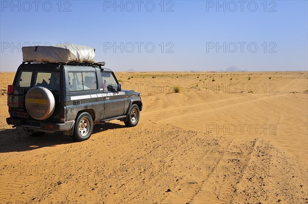 All-terrain vehicle with a roof tent on the dirt track