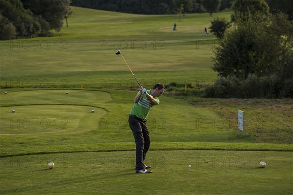 Golfer striking the ball on a golf course