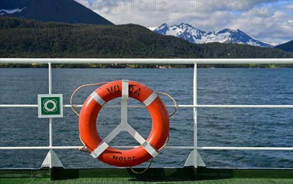 Lifebuoy on ferry Volda in front of a fjord landscape