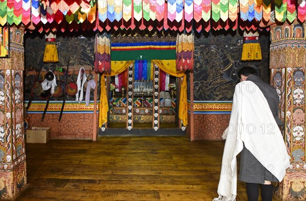 Bhutanese man at prayer at the holy shrine