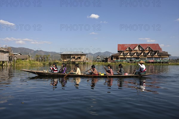 Local women in a wooden boat paddling on Inle Lake