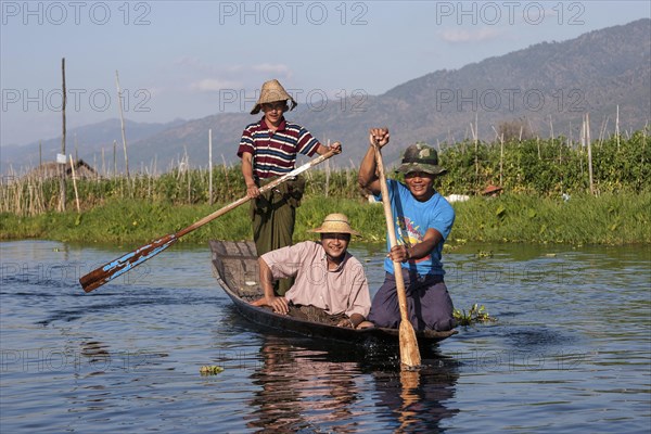 Local men paddling in a wooden boat on Inle Lake