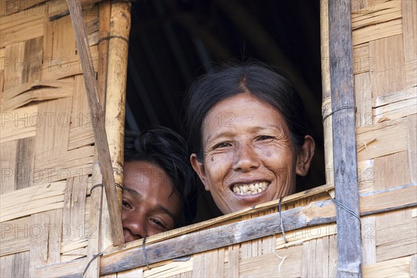 Native woman and boy looking out of a window