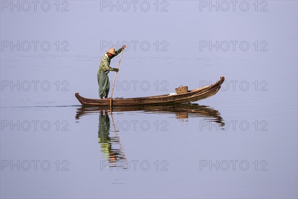 Local man on a wooden boat on the Taungthaman lake