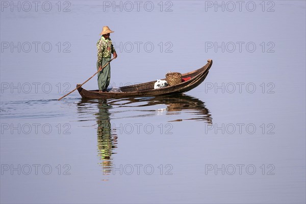 Local man on a wooden boat on the Taungthaman lake