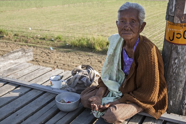 Native leper woman sitting on the U Bein Bridge