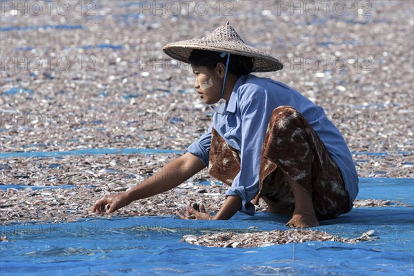 Local woman wearing straw hat and Thanaka paste on her face