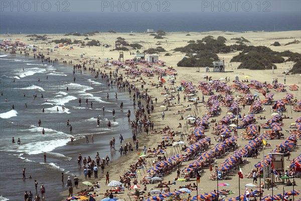 Crowded beach with umbrellas