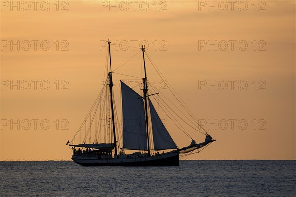 Sailboat in the Beau Vallon Bay in front of an orange sky