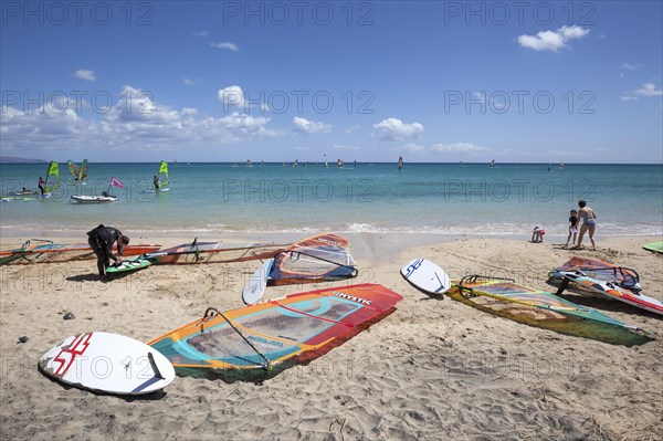 Windsurfing boards and sails lying on the beach