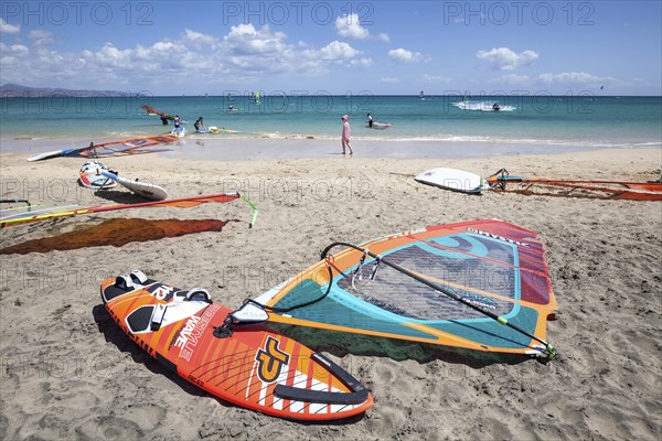 Windsurfing boards and sails lying on the beach