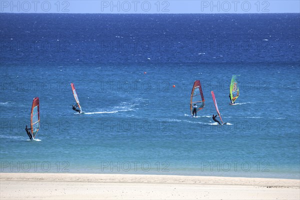 Windsurfers in the turquoise waters off the Playa Risco del Paso beach