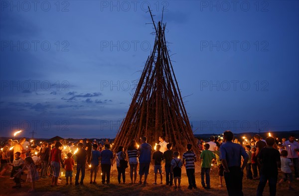 People standing around a Sonnwendfeuer bonfire