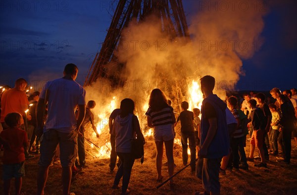 People standing around a Sonnwendfeuer bonfire