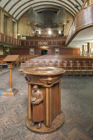 Wooden baptismal font decorated with carvings of a SA man in a storm-troopers' uniform