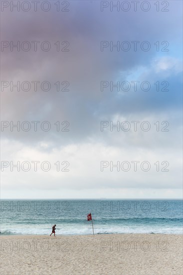 Man running in the early morning on Sao Conrado beach