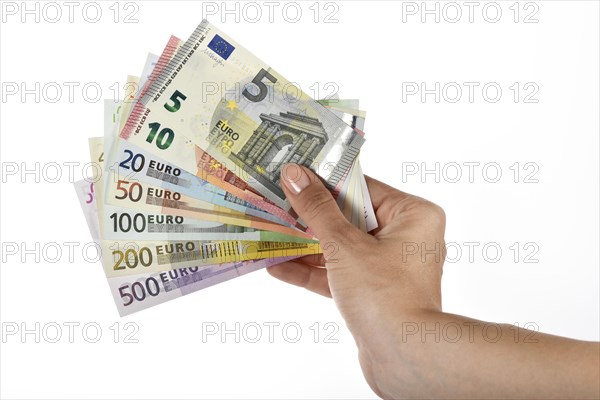 Woman's hand holding fan of various US Dollar notes